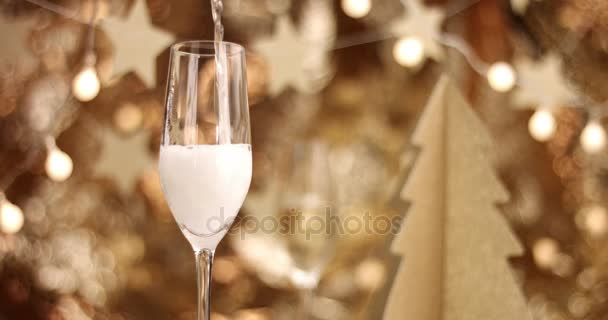 Шампанское налито в бокал с рождественскими украшениями — стоковое видео