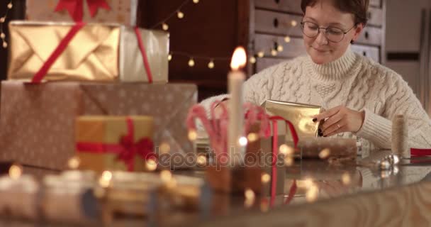 Χαριτωμένο νεαρή γυναίκα στο καλώδιο πουλόβερ περιτυλίγματος παρουσιάζει — Αρχείο Βίντεο