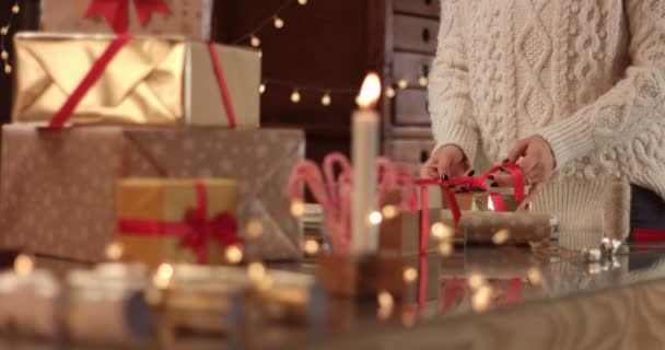 Leuke jonge vrouw in kabel trui verpakking presenteert — Stockvideo