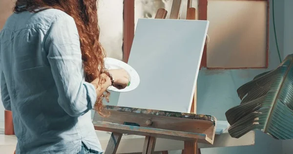 Bonito tintas menina de cabelos vermelhos em seu estúdio — Fotografia de Stock