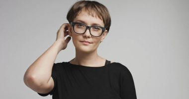 Renkli arka planlar üzerinde kısa saçlı sevimli genç kadın