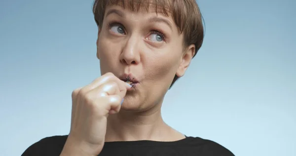 Ganska ung kvinna borsta hennes tänder med svart tandkräm — Stockfoto