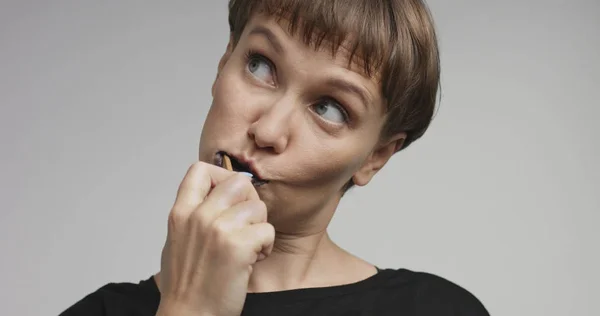 Pen ung kvinne som pusser tennene med svart tannkrem – stockfoto