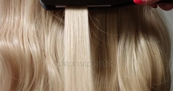Styling blond hair with hair straightener — Stock Video