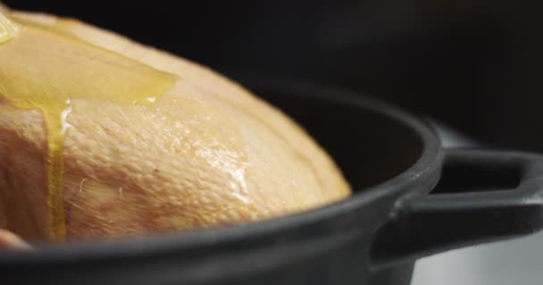 Мужчина-повар готовит жареного цыпленка с апельсином и розмарином — стоковое видео