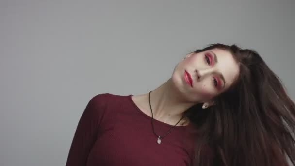 Красота испанская женщина в красном платье с ярким красным глазом макияж глядя в камеру — стоковое видео
