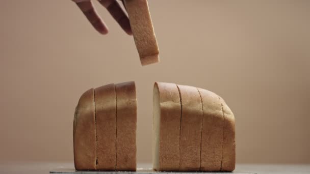 Mans hand puts back a slice of bread from brick bread — Stock Video