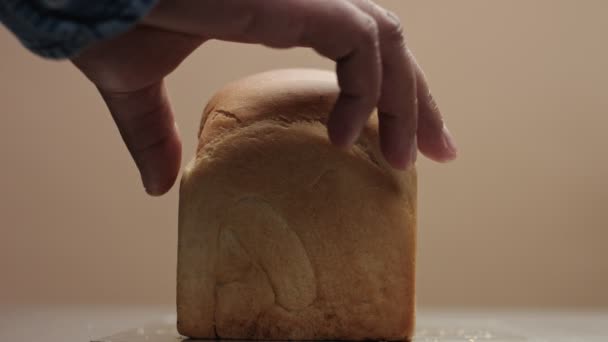 Vista frontal de ladrillo de pan. Mano de hombre quitar una parte delantera de pan para mostrar la parte interior del pan — Vídeos de Stock