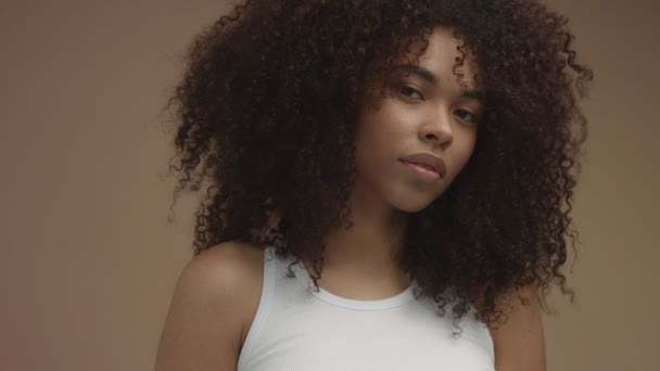 Retrato de movimento de panela de mulher negra com enorme cabelo encaracolado afro e pele brilhante — Vídeo de Stock