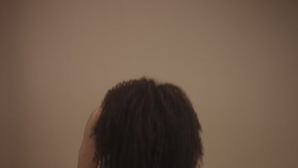 Замедленное движение черной женщины, поднимающей голову и трясущей волосы — стоковое видео