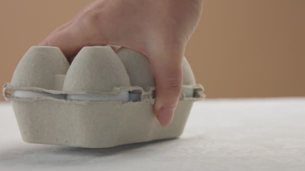 Жіноча рука поклала яєчну коробку в перспективу — стокове відео