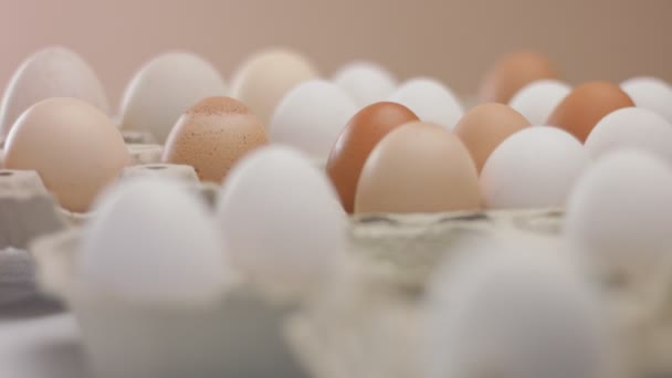 Movimiento de la sartén empujando huevos de diferentes colores y en la mano final de las mujeres sacar ane de huevo — Vídeo de stock