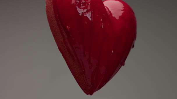 Corazón húmedo rojo volador en el aire con líquido transparente rojo lo cubrió y derramó sobre él — Vídeos de Stock