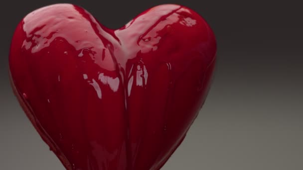 Fliegendes rotes, nasses Herz in der Luft mit roter, transparenter Flüssigkeit bedeckt und übergossen — Stockvideo