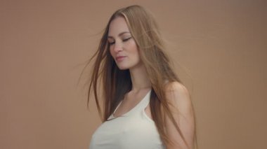 güzellik kadın modeli studio bej renkli arka plan üzerinde saç bllowing rüzgarda ile bu