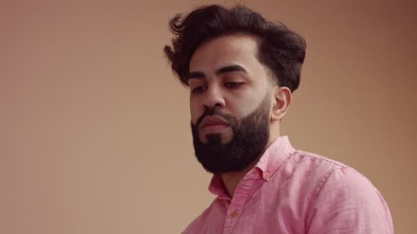 L'homme touche ses cheveux et regarde la caméra — Video