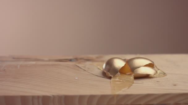 Slowmotion hur gyllene ägg fallande och brutna — Stockvideo