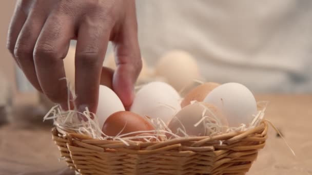 El hombre toma huevos de la cesta y los pone en los baxos — Vídeo de stock