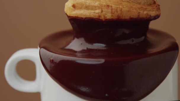 gros plan de croissant plonger dans le chocolat chaud dans la tasse 