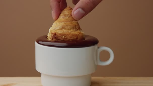 Primer plano de croissant sumergirse en chocolate caliente en la taza — Vídeo de stock