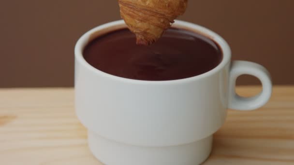 在杯中浸泡在热巧克力中的羊角面包特写 — 图库视频影像