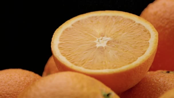 Primer plano de las naranjas sobre fondo negro — Vídeo de stock