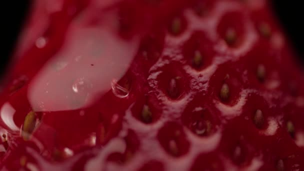Macro de textura de fresa y una gota trandparent en él — Vídeos de Stock