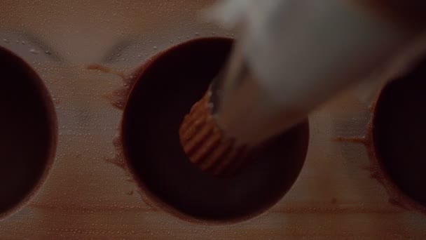 Close-up de saco de pastelaria preenchendo forma de molde de doces com creme de chocolate — Vídeo de Stock