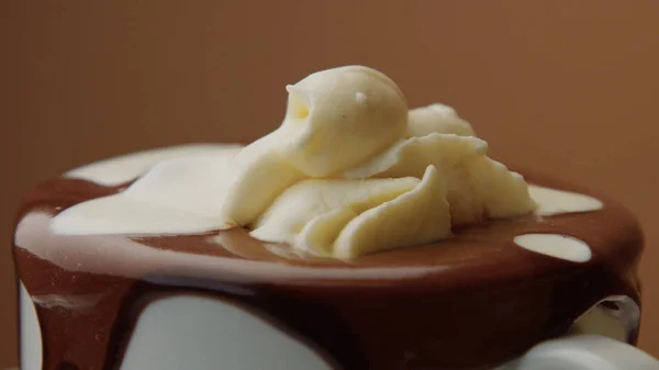 Taza de chocolate caliente con una crema y chocolate blanco líquido vertiendo sobre ella —  Fotos de Stock