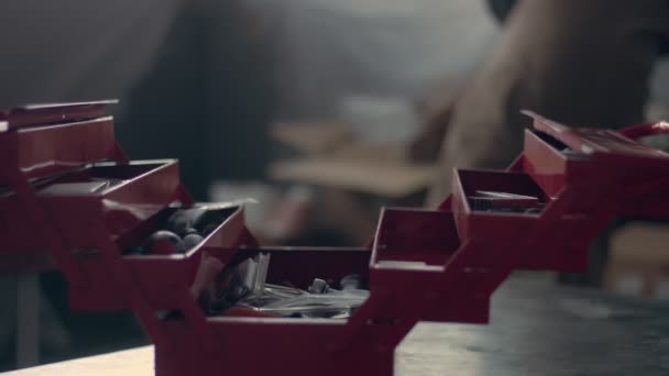 Worker in his garage with a red tool storage box — Stock Video