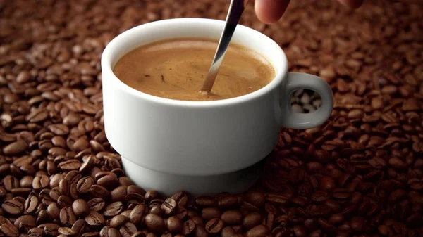 Zijaanzicht van witte kop zwarte koffie op koffiebonen — Stockfoto