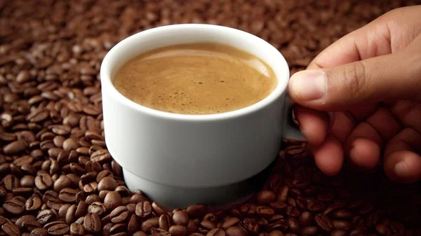 Zijaanzicht van witte kop zwarte koffie op koffiebonen — Stockfoto