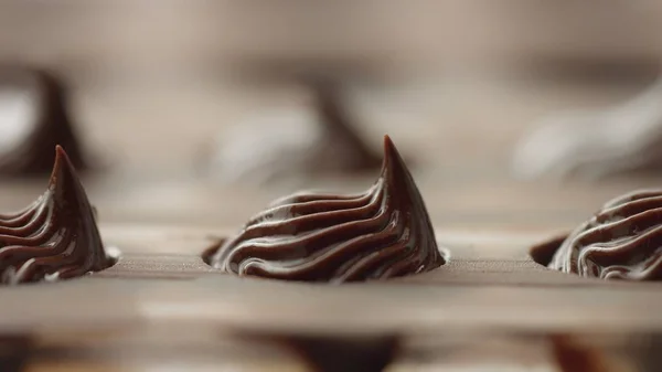 Close-up de saco de pastelaria preenchendo forma de molde de doces com creme de chocolate — Fotografia de Stock