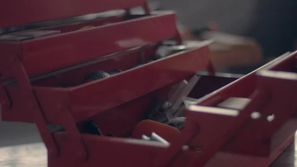 Arbeiter in seiner Garage mit einem roten Werkzeugkasten — Stockfoto