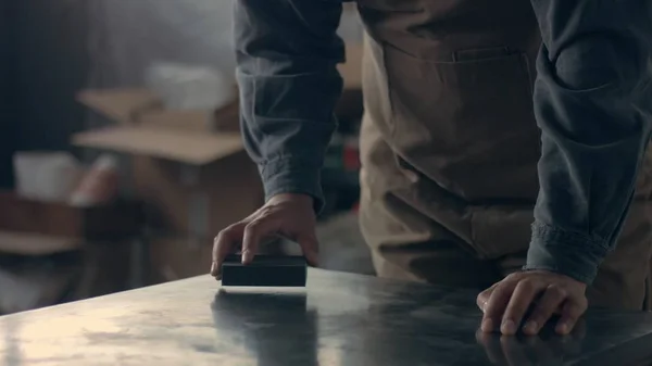 Hombre lijando una mesa de metal — Foto de Stock