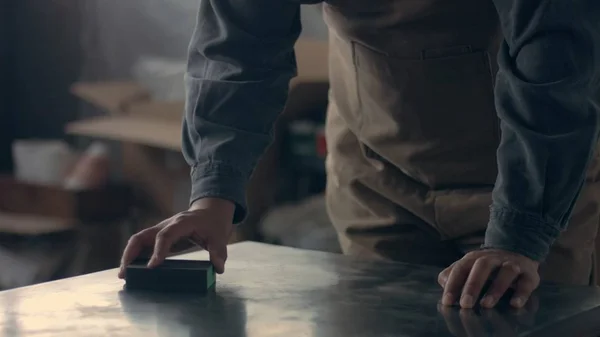 Hombre lijando una mesa de metal — Foto de Stock