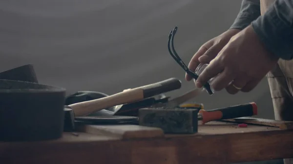 Many tools on the worker table and his hand choosing one of tool — Stock Photo, Image