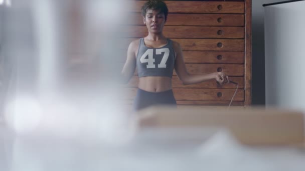 Mujer de raza mixta durante el entrenamiento de cuerda de salto en el loft soleado — Vídeo de stock