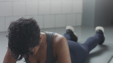 Genç zinde ve ses kadının yapması için güneşli çatı katında güç abs fitness egzersiz tahta elemanları ile yukarıya