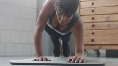 Genç zinde ve ses kadının yapması için güneşli çatı katında güç abs fitness egzersiz tahta elemanları ile yukarıya