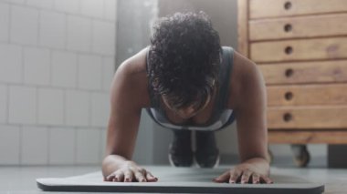 Genç zinde ve ses kadının yapması için güneşli çatı katında güç abs fitness egzersiz tahta elemanları ile yukarıya