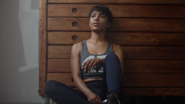 Giovane in forma e tonificare donna siede magra su armadio in legno durante il riposo allenamento — Video Stock