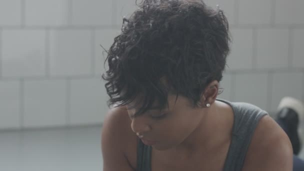 Jeune ajustement et tonifier femme faisant entraînement de remise en forme avec des éléments de planche pour abdos tendus dans loft ensoleillé — Video