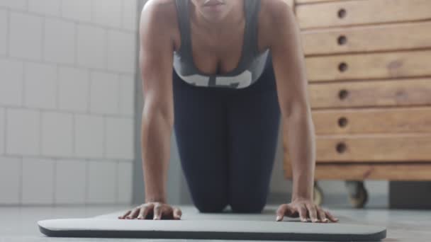 Jeune ajustement et tonifier femme faisant entraînement de remise en forme avec des éléments de planche pour abdos tendus dans loft ensoleillé — Video