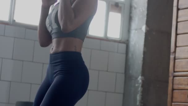 Молода змішана раса афроамериканська жінка робить бокс тренування в сонячному лофт — стокове відео