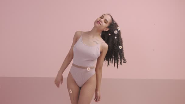 Pretty young woman in studio with flowers in head — Stock Video