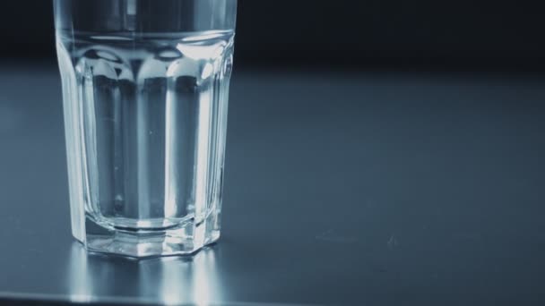 Närbild slowmotion av glas fulling med vatten — Stockvideo