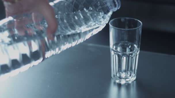 ralenti en gros plan du verre rempli d'eau de la bouteille 