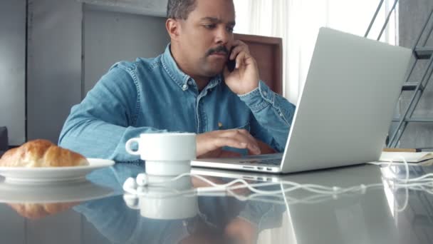Взрослый мужчина смешанной расы работает в студии с ноутбуком — стоковое видео