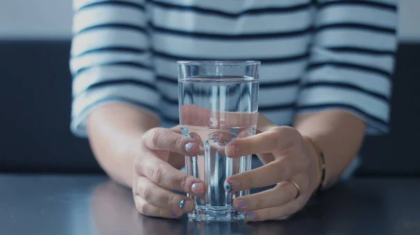 Primo piano delle donne mano con un bicchiere d'acqua — Foto Stock